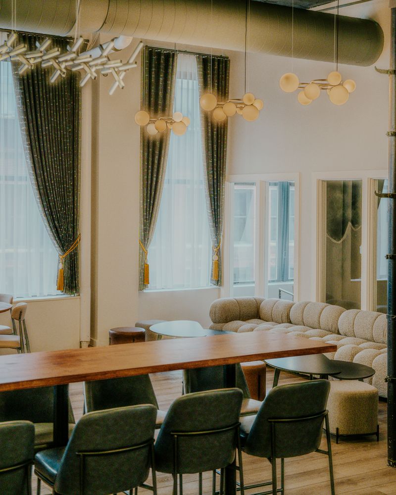 Private dining room with wooden table, green chairs and banquette seating